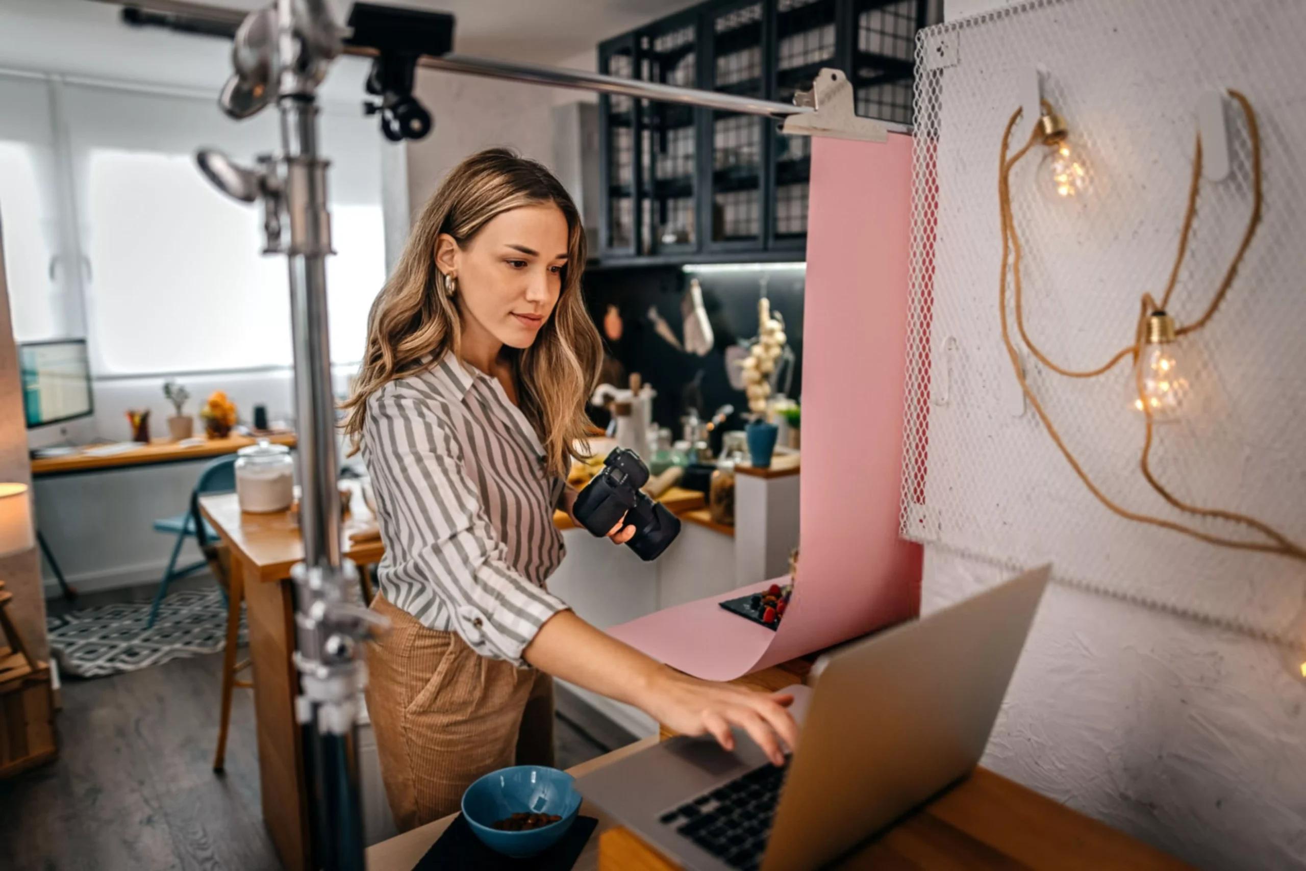 Female food blogger shooting food with camera and laptop