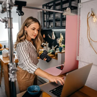 Female food blogger shooting food with camera and laptop